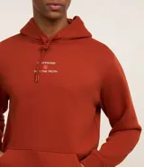 Sudadera con capucha color ladrillo, con cordón ajustable, bolsillo tipo canguro y puños acanalados. Estampa frontal con la frase "Love Found, Serenity Truth".