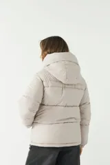 Campera puffer larga con cuello alto y capucha, presenta cierre metálico y puños elastizados.