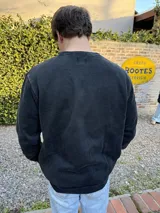 Buzo negro de algodón con efecto lavado y pequeño logo bordado en el pecho.