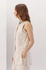 Chaleco color beige confeccionado en lino y rayon, con escote en V y cierre frontal con botones. Diseño clásico y favorecedor.
