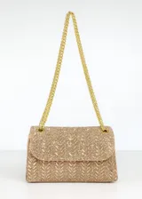 Cartera rígida dorada con acabado en strass y diseño geométrico. Tiene cadena metálica dorada para llevar al hombro o cruzada.