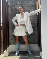 Blazer blanco con solapas de muesca, cierre cruzado con dos botones, bolsillos delanteros con solapa y corte recto.