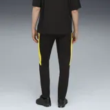 Pantalón de jogging negro con detalles en amarillo, logo de Puma bordado en amarillo y escudo del Club Atlético Peñarol bordado en amarillo.