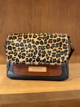 Bandolera de cuero con solapa superior de animal print y cuerpo inferior dividido en dos secciones: una de cuero marrón con textura y otra de cuero negro con textura.