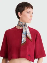 Pañuelo de seda Longchamp con estampado floral multicolor y borde marrón.