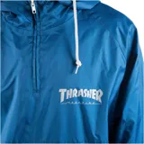 Campera anorak Thrasher de media cremallera, color azul con parte inferior negra y logo de la marca estampado en el pecho.