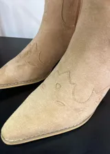 Botas texanas de gamuza color beige, con diseño bordado y cierre lateral.