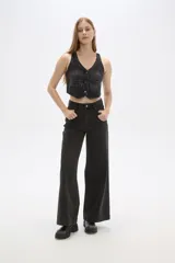 Chaleco de jean celeste sin mangas, con cuello en V, cierre frontal con botones y dos bolsillos con solapa en el pecho.