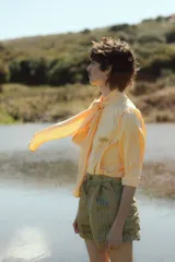 Short unisex color verde con rayas verticales, tiro alto, pinzas y bolsillos.