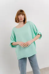 Blusa color beige confeccionada en lino, de corte holgado, mangas 3/4 y cuello redondo.