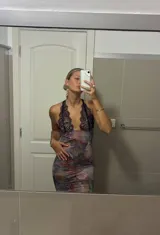 Vestido largo de microtul con estampado floral, escote en V profundo con borde de encaje negro y espalda descubierta con tirantes finos ajustables.