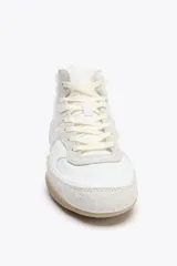 Botín deportivo blanco con detalles en beige y suela color caramelo. Cierre con cordones y puntera redonda.