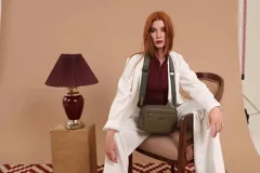 Bandolera color mostaza de simil cuero, con tres cierres principales, cierre delantero y bolsillo trasero. Incluye correa ajustable.