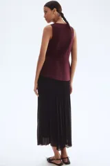 Pollera larga de gasa plisada color negro, de tiro alto con elástico fino en la cintura y bajo sobrehilado con vuelo. Forrada.