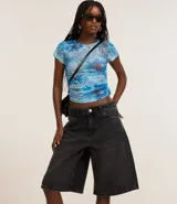 Bermuda femenina confeccionada en jeans color gris oscuro, modelo jorts, con trabillas en la cintura y bolsillos.