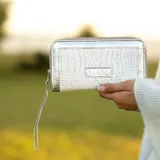 Billetera grande de cuero con estampado animal print y cierre de cremallera.