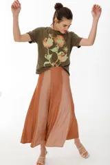 Falda larga de tiro medio con diseño de paneles intercalados en tejido ligero color marrón.