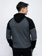 Campera con capucha Umbro de piqué, color gris con mangas negras y logo bordado en blanco.