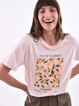 Remera color amarillo claro con estampado de limones, hojas y flores en tonos verdes y grises.