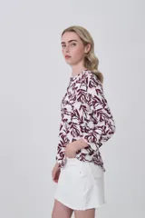 Camisa de manga larga con cuello mao y estampado paisley en tonos blanco, verde oliva y rosado. Presenta un calce holgado y bolsillos frontales.