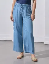 Pantalón de lyocell celeste, de corte ancho, con pretina elastizada con lazo de ajuste, bolsillos laterales y bolsillos cargo.