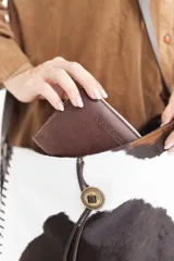 Bolso tipo tote de cuero marrón con textura de cocodrilo, doble asa corta y cierre superior.