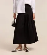 Falda midi evasé negra, confeccionada en tricolina, con pliegues y sin estampado.