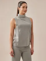 Polera gris melange de tejido de punto con cuello alto y sin mangas.