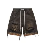 Short de jean negro con efecto desgastado, roturas y tachas metálicas.