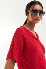 Remera de tejido de punto calado color rojo, con cuello polo y mangas cortas.