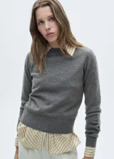 Sweater gris de punto con cuello redondo y mangas largas.