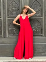 Mono de fiesta rojo con escote en V, breteles finos con apliques de strass y corte palazzo.