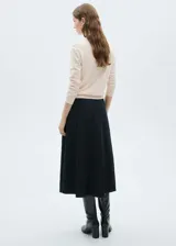 Jersey de punto fino color crudo, con cuello redondo y mangas largas.