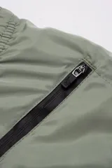 Short de baño gris claro, con cintura elástica ajustable, dos bolsillos laterales y uno trasero con cierre. Tiene suspensor de malla fina hipoalergénico y protección UV 50.