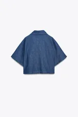 Camisa corta de denim azul, con cuello solapa, escote en pico y mangas cortas.