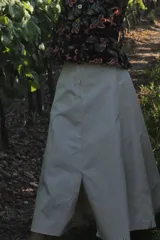 Falda midi color beige, de corte acampanado y abertura trasera.