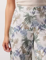 Pantalón crop de lino estampado con hojas en tonos verdes y azules. Tiene pretina trasera elastizada y bolsillos delanteros.