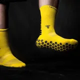 Medias amarillas con diseño acanalado y logo de la marca en negro. Poseen puntos antideslizantes en la planta del pie.