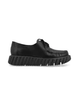 Zapato acordonado de cuero liso negro con detalle de cuero charol en la puntera y cordones finos. Suela de goma con plataforma dentada.