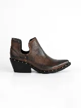 Botín negro de cuero vacuno con punta fina, laterales con corte asimétrico y detalle de tachas plateadas en el borde. Tiene un taco cuadrado de 5 cm y suela de caucho antideslizante.