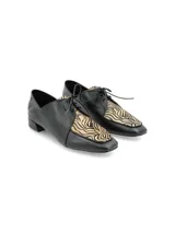 Zapato de cuero negro con cordones, punta fina y aplique de cuero con estampado animal print.