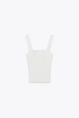 Top blanco de tejido de canalé, con escote recto y tirantes anchos con detalle de encaje.