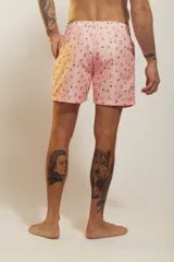 Bañador de hombre color rosa pálido con estampado de golondrinas oscuras. Presenta cintura elástica con cordón ajustable de color crudo y terminales turquesa.