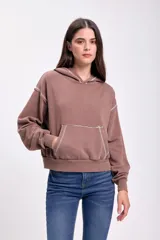 Canguro deportivo marrón con efecto lavado, capucha con cordón ajustable, bolsillo tipo canguro y puños y cintura acanalados.