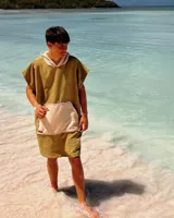 Poncho de toalla verde oliva con capucha y bolsillo canguro beige.