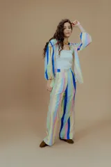 Pantalón de vestir de tiro alto con estampado a rayas verticales de colores pastel y azul. Corte recto con pinzas en la cintura.