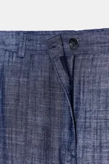 Pantalón azul con textura, de tiro medio, con bolsillos delanteros y traseros. Cierre frontal con cremallera y botón.