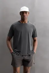 Camiseta deportiva verde militar confeccionada en tejido estructurado, ligero y elástico. Tiene cuello redondo, manga corta y bajo con aberturas laterales. Incluye logo estampado en el bajo.