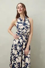 Vestido largo de algodón liviano con estampado floral en tonos azul y blanco, escote halter y lazo que se anuda al cuello.