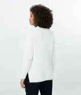 Suéter blanco de punto trenzado con cuello redondo y mangas largas.